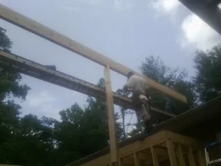 Carpenter setting a ridge beam over a new addition frame — Ice Dam Removal by Roofing Brothers in Blakely Island